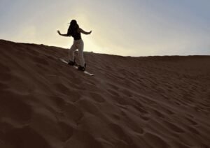 Viaggio deserto Marocco con carovana di cammelli e tramonto sulle grandi dune con vista panoramica sul deserto marocchino